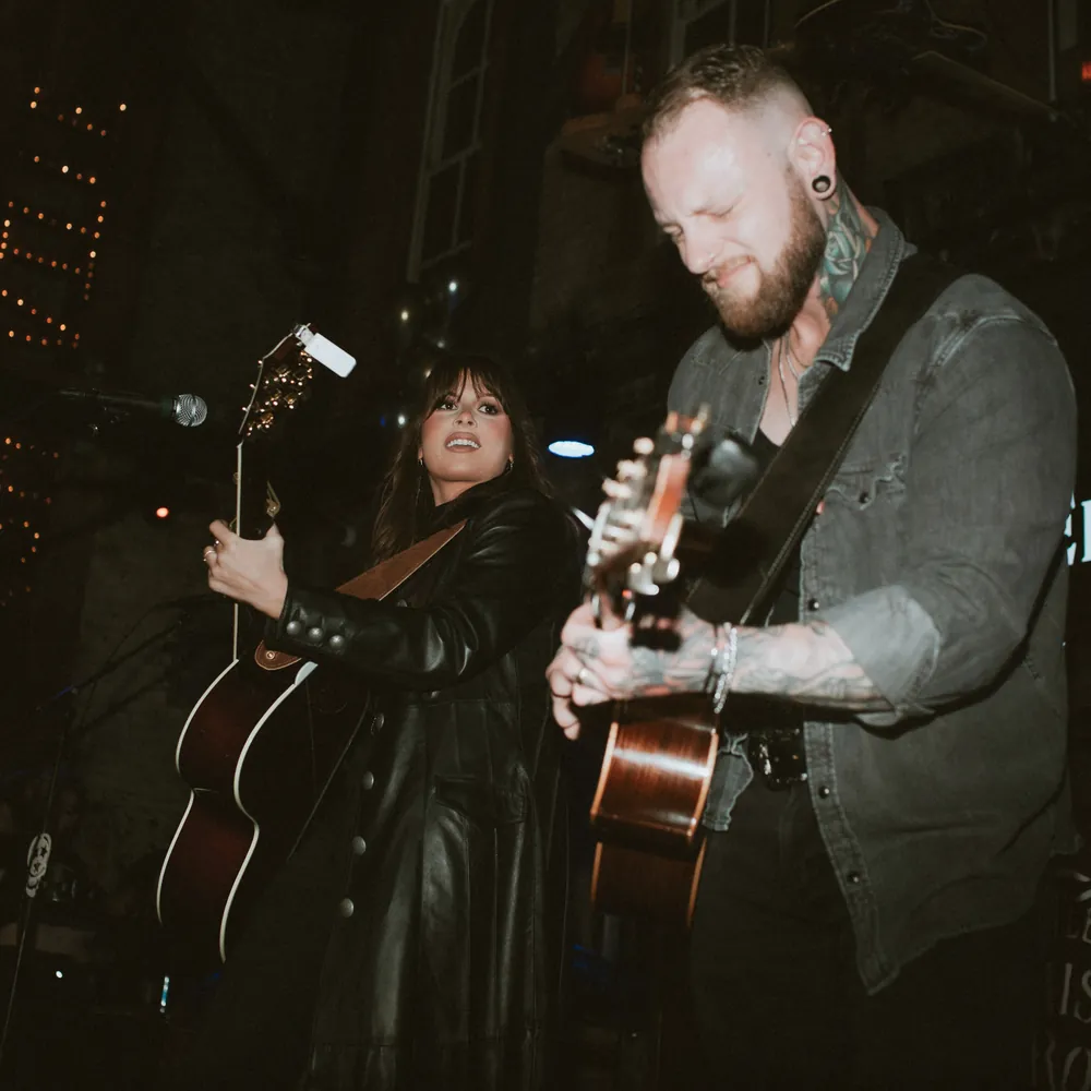Two musicians playing acoustic guitars on stage during live country music at Dierks Bentley's Whiskey Row